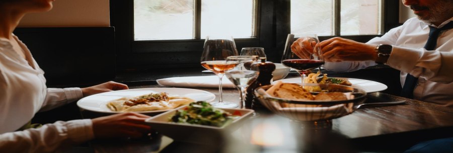 Two people are enjoying a meal in a restaurant. There is wine, bread and salad on the table. The atmosphere is cozy and elegant., &copy; &copy; Stuttgart-Marketing GmbH, Alwin Maigler