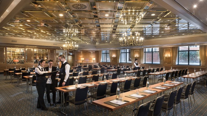 Eleganter Konferenzsaal im Maritim Hotel Stuttgart mit gedeckten Tischen, Kronleuchtern und Personal in Vorbereitung., &copy; Maritim Hotels