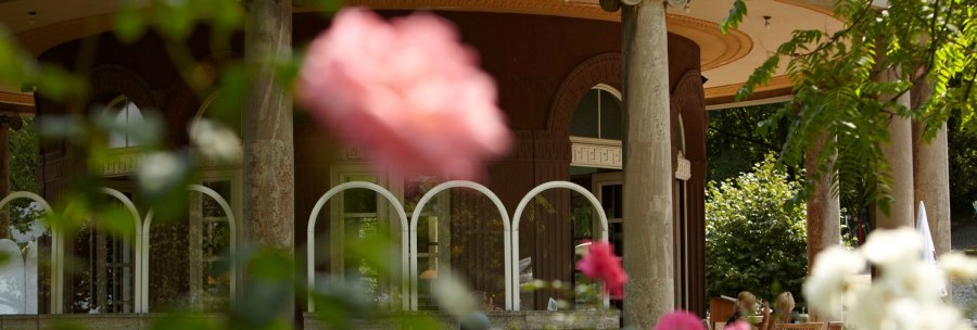 The tea house in Stuttgart's Weißenburgpark, surrounded by blooming roses and green leaves. Columns and windows are visible., © Stuttgart-Marketing GmbH Christoph Düpper