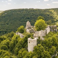 The Hohenurach castle ruins sit atop a wooded hill, surrounded by lush nature and rolling hills beneath a clear sky., © SMG Stuttgart Marketing GmbH - Sarah Schmid The Hohenurach castle ruins sit atop a wooded hill, surrounded by lush nature and rolling hills beneath a clear sky., © SMG Stuttgart Marketing GmbH - Sarah Schmid