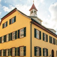 A historic building in Gerlingen with a yellow facade and green shutters. The sky is blue with a few clouds., © SMG Stuttgart Marketing GmbH - Sarah Schmid A historic building in Gerlingen with a yellow facade and green shutters. The sky is blue with a few clouds., © SMG Stuttgart Marketing GmbH - Sarah Schmid