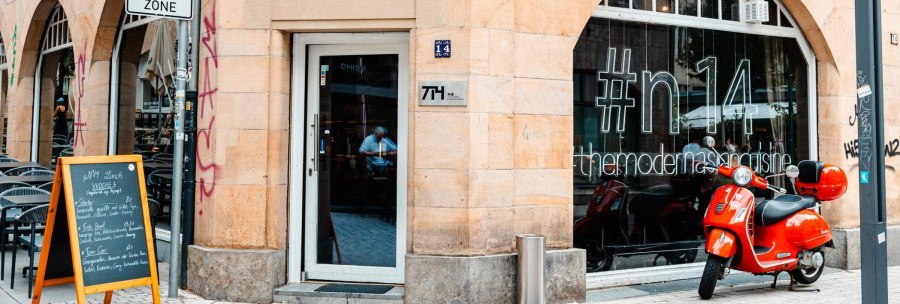 Eingang eines Restaurants mit '#n14' auf dem Fenster. Ein roter Motorroller steht davor. Ein Schild mit Tagesmen&uuml; ist aufgestellt., &copy; Stuttgart Marketing GmbH, Sarah Schmid