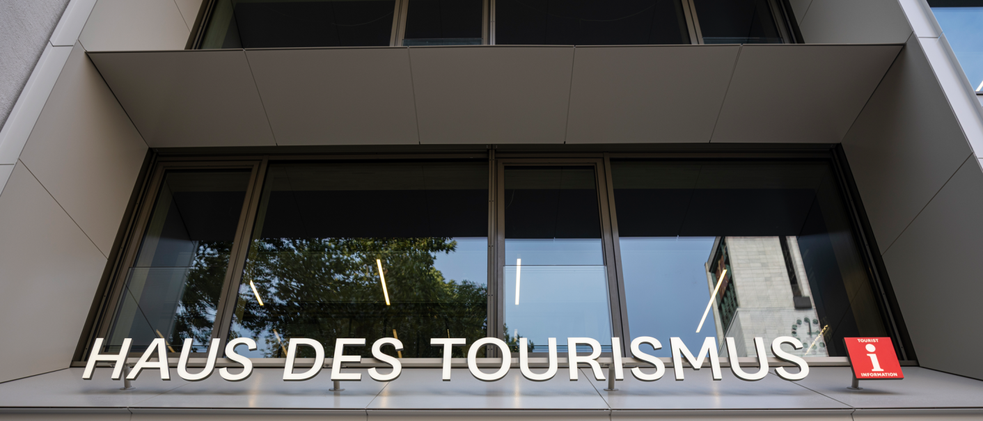 Modern façade of the Haus des Tourismus with large lettering and tourist information sign., © Stuttgart-Marketing GmbH, Sarah Schmid Modern façade of the Haus des Tourismus with large lettering and tourist information sign., © Stuttgart-Marketing GmbH, Sarah Schmid
