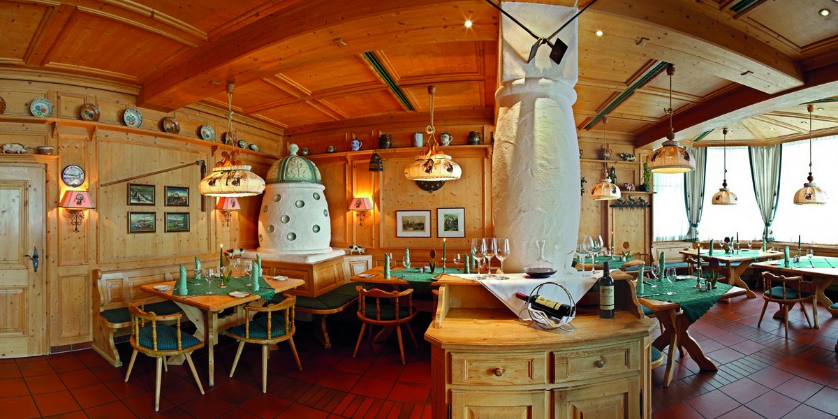 Cozy Black Forest-style restaurant with wooden furniture, tiled stove and decorative plates. Tables are laid, the atmosphere is inviting and traditional., © © H-Hotels.com Cozy Black Forest-style restaurant with wooden furniture, tiled stove and decorative plates. Tables are laid, the atmosphere is inviting and traditional., © © H-Hotels.com