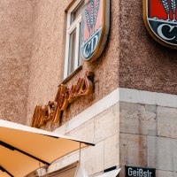 Gebäudefassade mit 'Mrs. Jones'-Schriftzug und Wappen 'CD' über einem Straßenschild 'Geißstr.'., © SMG Stuttgart Marketing GmbH - Sarah Schmid Gebäudefassade mit 'Mrs. Jones'-Schriftzug und Wappen 'CD' über einem Straßenschild 'Geißstr.'., © SMG Stuttgart Marketing GmbH - Sarah Schmid