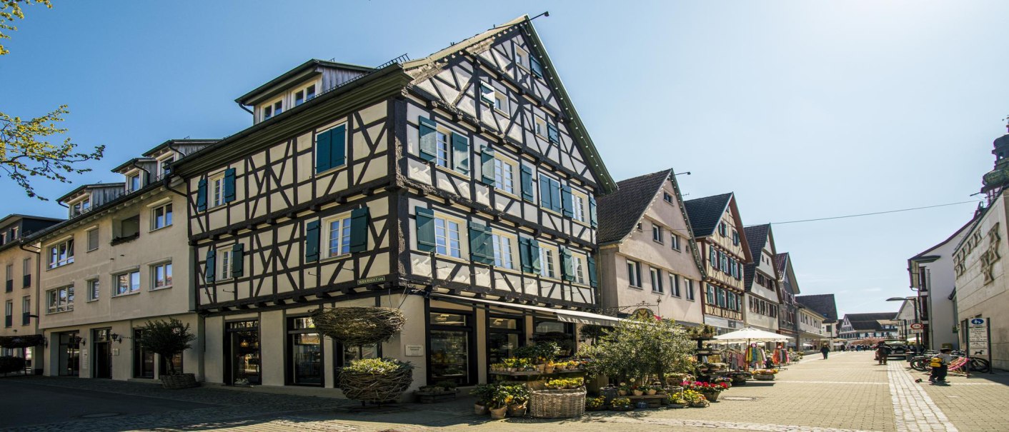 Half-timbered houses in the old town of Kirchheim unter Teck, sunny day, stores and flowers in the street., © SMG Stuttgart Marketing GmbH - Sarah Schmid