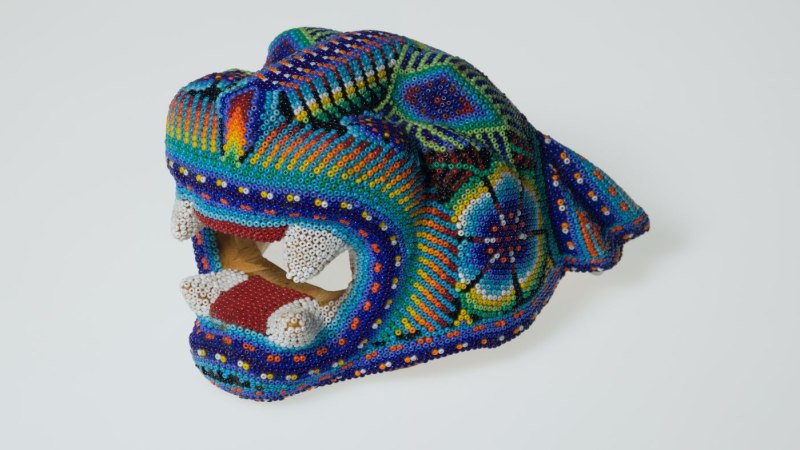 Eine bunte Perlenmaske in Form eines Tierkopfes mit ge&ouml;ffnetem Maul. Die Maske ist kunstvoll mit Mustern verziert., &copy; Linden-Museum Stuttgart