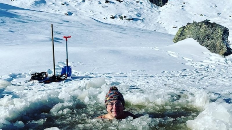 Eine Person badet in einem Eisloch in einer verschneiten Berglandschaft. Im Hintergrund sind Berge und Bäume zu sehen., © Renitenztheater Stuttgart e.V. Eine Person badet in einem Eisloch in einer verschneiten Berglandschaft. Im Hintergrund sind Berge und Bäume zu sehen., © Renitenztheater Stuttgart e.V.