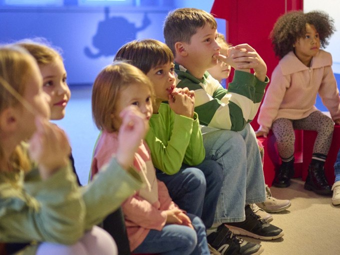 Kindergruppe sitzt aufmerksam auf dem Boden und schaut gespannt nach vorne. Hintergrund unscharf, bunte Kleidung., © Landesmuseum Württemberg Kindergruppe sitzt aufmerksam auf dem Boden und schaut gespannt nach vorne. Hintergrund unscharf, bunte Kleidung., © Landesmuseum Württemberg