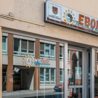 Eingang des Restaurants 'Ebony' mit Schildern für afrikanische Küche. Fenster spiegeln die gegenüberliegende Straße wider. Seit 1987 geöffnet., © SMG, Sarah Schmid Eingang des Restaurants 'Ebony' mit Schildern für afrikanische Küche. Fenster spiegeln die gegenüberliegende Straße wider. Seit 1987 geöffnet., © SMG, Sarah Schmid