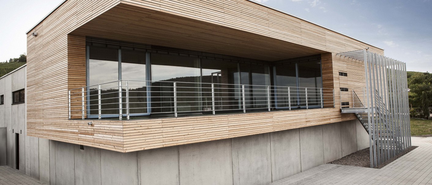 Modernes Gebäude mit Holzverkleidung, großen Fenstern und Metallgeländer. Außenansicht bei Tageslicht, klare Linien und minimalistisches Design., © Weingut Knauß Modernes Gebäude mit Holzverkleidung, großen Fenstern und Metallgeländer. Außenansicht bei Tageslicht, klare Linien und minimalistisches Design., © Weingut Knauß