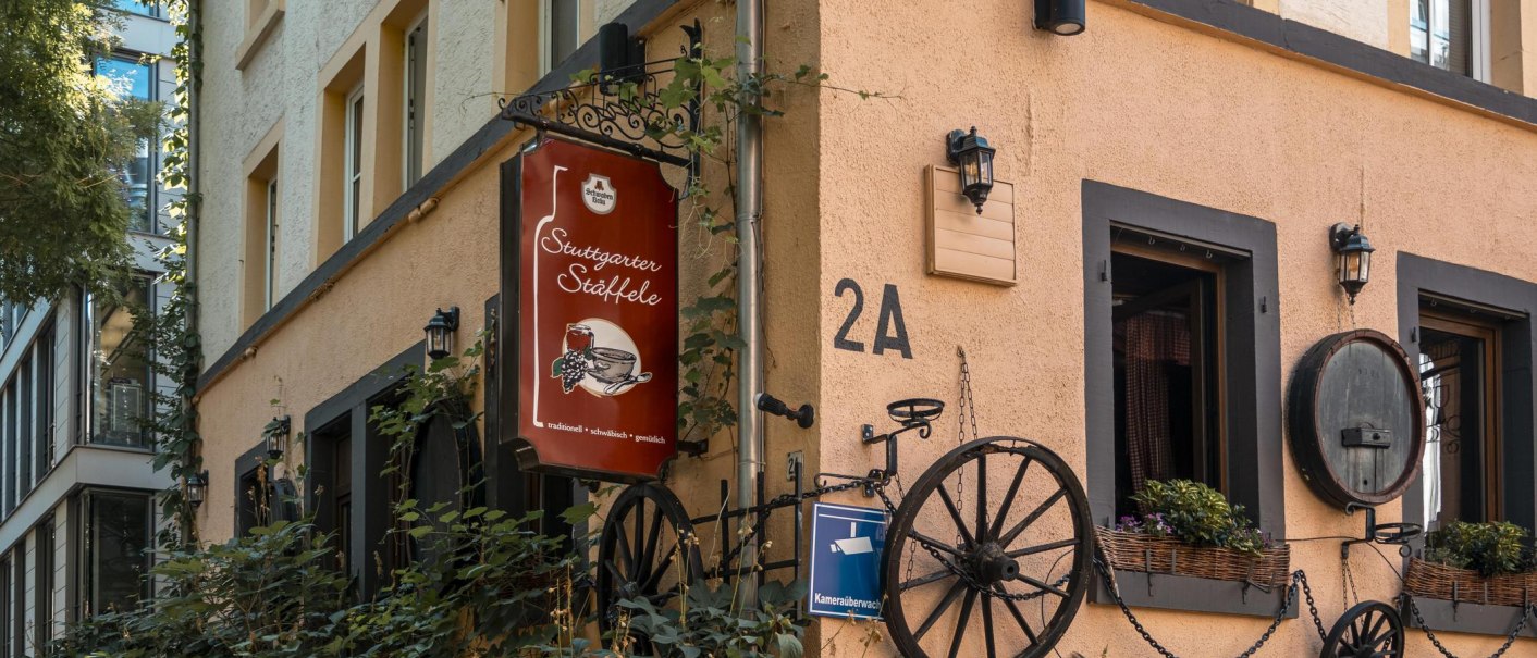 Geb&auml;ude mit Schild 'Stuttgarter St&auml;ffele', dekoriert mit Pflanzen und alten Wagenr&auml;dern. Adresse 2A, &Uuml;berwachungskamera-Schild sichtbar., &copy; SMG, Sarah Schmid