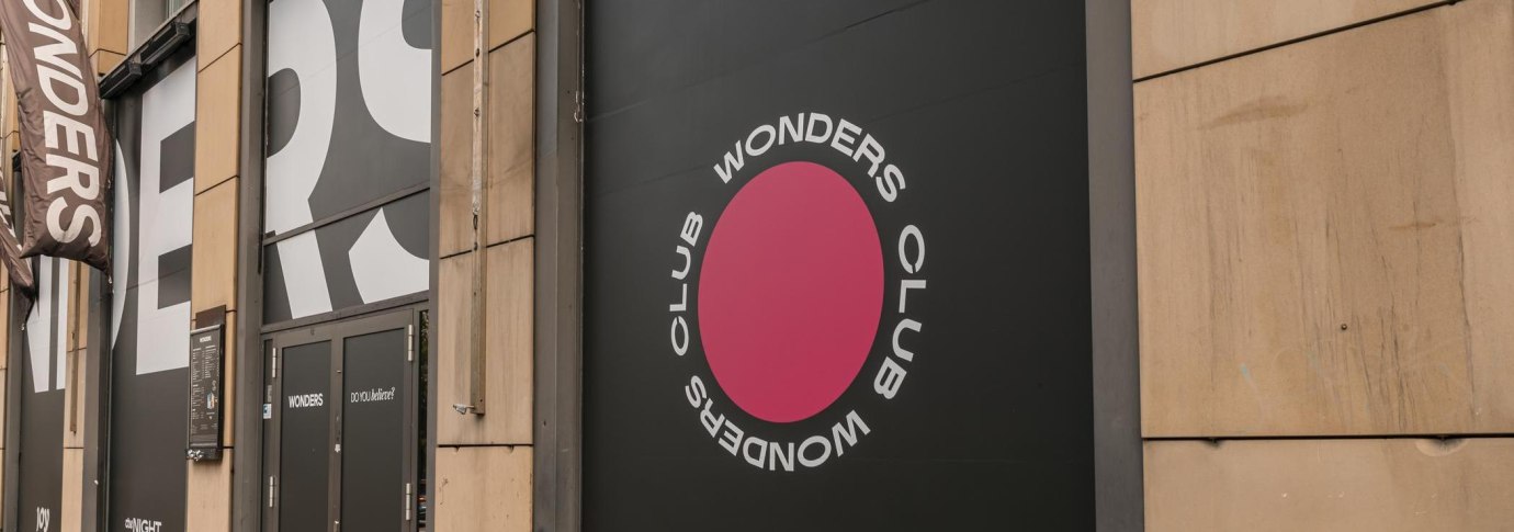 Eingang des Wonders Club mit gro&szlig;em Logo und Schriftzug an der Fassade. Schwarze T&uuml;ren und ein pinker Kreis mit dem Text 'Wonders Club'., &copy; Stuttgart Marketing GmbH, Sarah Schmid