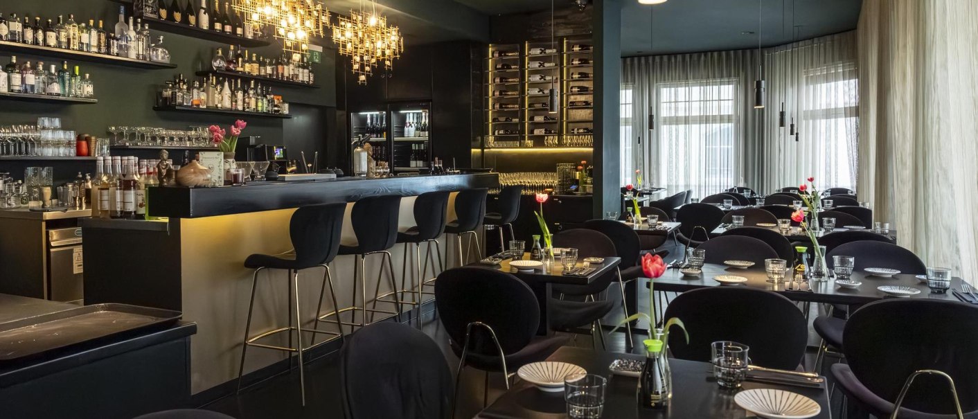 Elegantes Restaurant mit stilvoller Bar, modernen Leuchten und gedeckten Tischen. Tulpen als Dekoration, gemütliche Atmosphäre., © Stuttgart-Marketing GmbH, Sarah Schmid