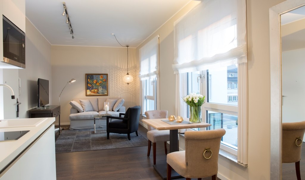 Bright executive suite with stylish living room, dining table and kitchenette. Large windows, modern furnishings and inviting atmosphere., © Hotel LOGIS Bright executive suite with stylish living room, dining table and kitchenette. Large windows, modern furnishings and inviting atmosphere., © Hotel LOGIS