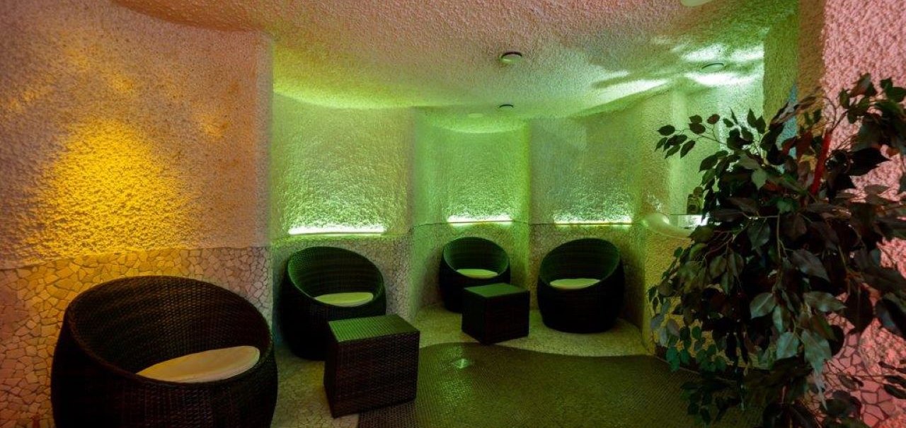 Ein gemütlicher Wellnessbereich mit runden Korbsesseln, gedämpfter Beleuchtung in warmen Farben und einer Pflanze in der Ecke., © Kronen Hotel GmbH Ein gemütlicher Wellnessbereich mit runden Korbsesseln, gedämpfter Beleuchtung in warmen Farben und einer Pflanze in der Ecke., © Kronen Hotel GmbH