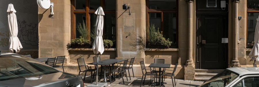 Building with tables and chairs on the sidewalk, sunshades and a sign with 'MISIK'. Historic fa&ccedil;ade with large windows., &copy; SMG Stuttgart Marketing GmbH - Sarah Schmid