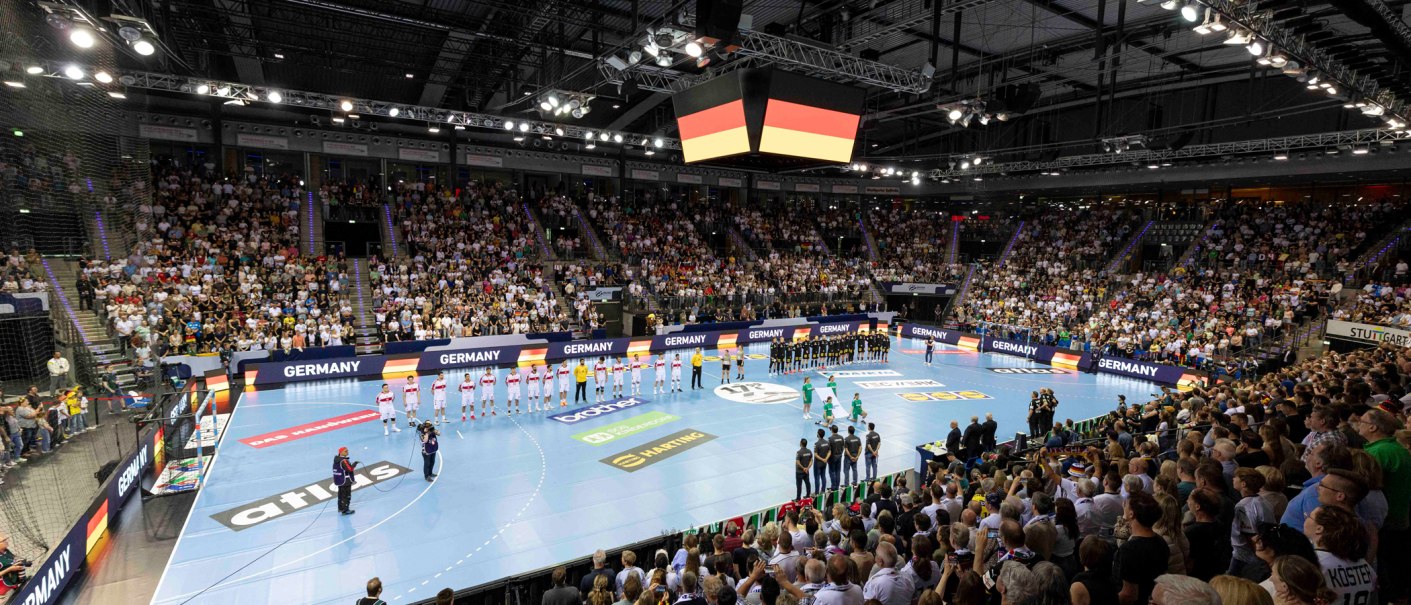 Handball-Länderspiel in einer vollen Arena. Zwei Mannschaften stehen auf dem Spielfeld, während die Zuschauer die Nationalhymne hören., © Kenny Beele Handball-Länderspiel in einer vollen Arena. Zwei Mannschaften stehen auf dem Spielfeld, während die Zuschauer die Nationalhymne hören., © Kenny Beele