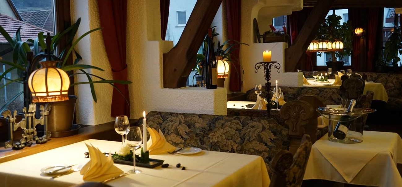 Ein gemütliches Restaurant mit Kerzenlicht, gedeckten Tischen und dekorativen Pflanzen. Die Atmosphäre ist warm und einladend., © Hotel & Restaurant Beurener Hof Ein gemütliches Restaurant mit Kerzenlicht, gedeckten Tischen und dekorativen Pflanzen. Die Atmosphäre ist warm und einladend., © Hotel & Restaurant Beurener Hof