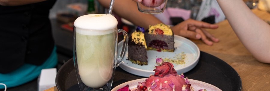Two people toast with drinks while cake is served on the table. One drink has a froth, the cake is decorated., © � 2022 Anastasiia Vovk, all rights reserved. Two people toast with drinks while cake is served on the table. One drink has a froth, the cake is decorated., © � 2022 Anastasiia Vovk, all rights reserved.
