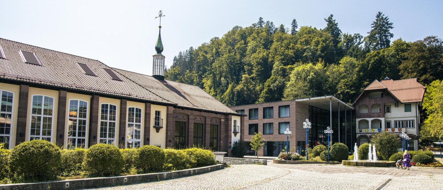 Historic building in Bad Liebenzell with a modern extension, surrounded by trees and a paved square with a fountain., © Stuttgart-Marketing GmbH, Sarah Schmid Historic building in Bad Liebenzell with a modern extension, surrounded by trees and a paved square with a fountain., © Stuttgart-Marketing GmbH, Sarah Schmid