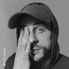 Person mit Kapuze und Mütze hält eine Hand über das Gesicht. Schwarz-weiß Bild., © links im Bild Person mit Kapuze und Mütze hält eine Hand über das Gesicht. Schwarz-weiß Bild., © links im Bild