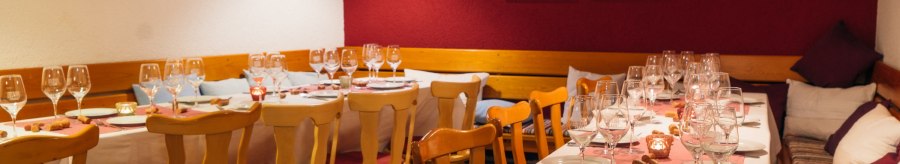 Comfortably laid table in a restaurant with wine glasses, candles and wooden furniture. The walls are decorated in red and white., &copy; 70469R! Weinbau Fabian Rajtschan