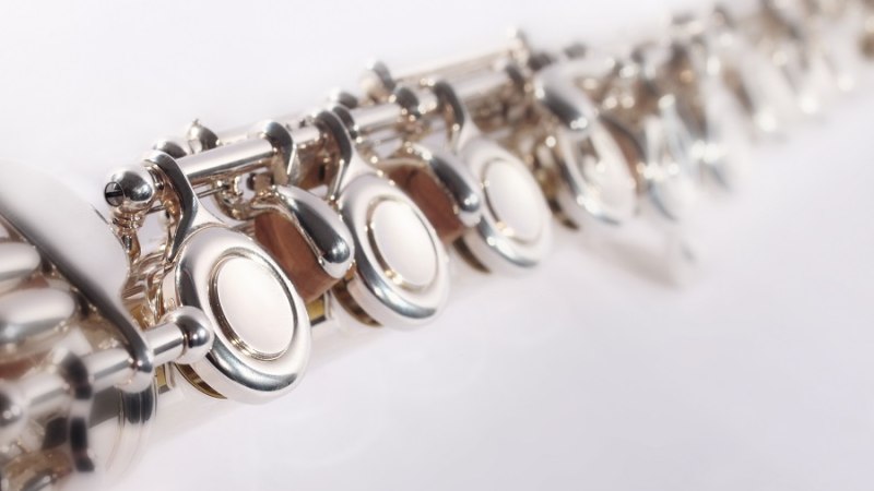 Nahaufnahme einer silbernen Querflöte, die Klappen sind im Fokus. Der Hintergrund ist unscharf., © Christian Steeneck