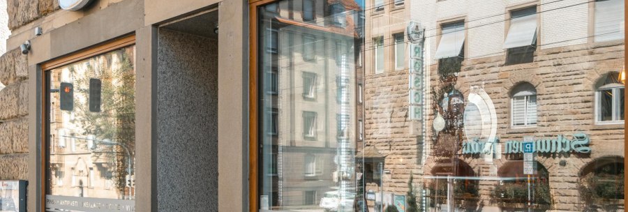 Au&szlig;enansicht eines Restaurants mit der Aufschrift 'Pinsa Manufaktur' und Spiegelung von Geb&auml;uden im Fenster., &copy; SMG, Sarah Schmid