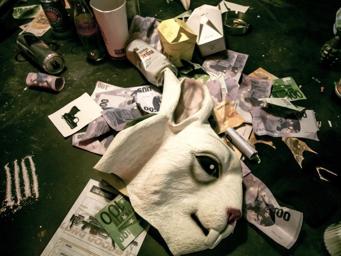 Ein Tisch mit einer Hasenmaske, Geldscheinen, Getränkedosen und weißen Linien. Chaos und Unordnung dominieren die Szene., © ExitGames Stuttgart Ein Tisch mit einer Hasenmaske, Geldscheinen, Getränkedosen und weißen Linien. Chaos und Unordnung dominieren die Szene., © ExitGames Stuttgart