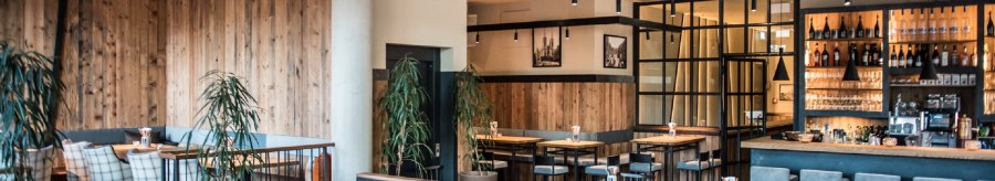 Modern brewery with wooden furniture, bar and plants. Cozy atmosphere with wooden walls and stylish lighting., © Andreas Engelhard - Engelhard Photography