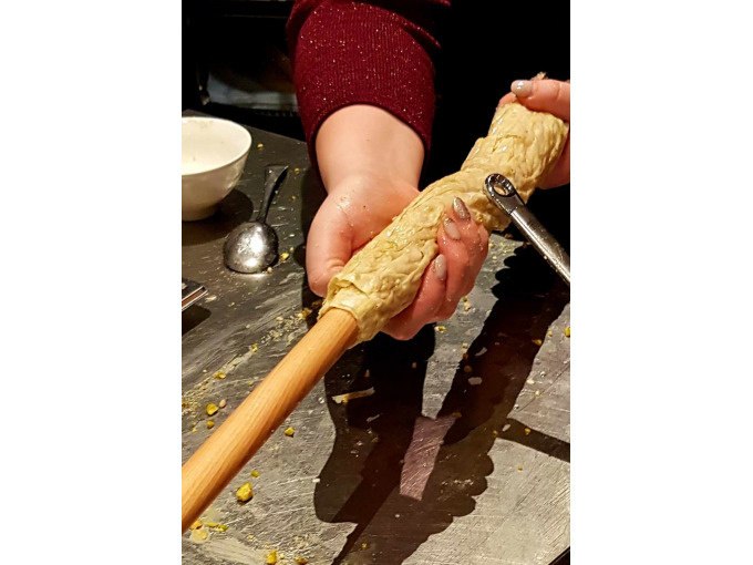 Eine Person rollt Teig um ein Nudelholz. Im Hintergrund sind eine Schüssel und ein Löffel zu sehen., © Kultweine-Kochwelten-Kunstücke - Kochschule Sonja Lenz Eine Person rollt Teig um ein Nudelholz. Im Hintergrund sind eine Schüssel und ein Löffel zu sehen., © Kultweine-Kochwelten-Kunstücke - Kochschule Sonja Lenz